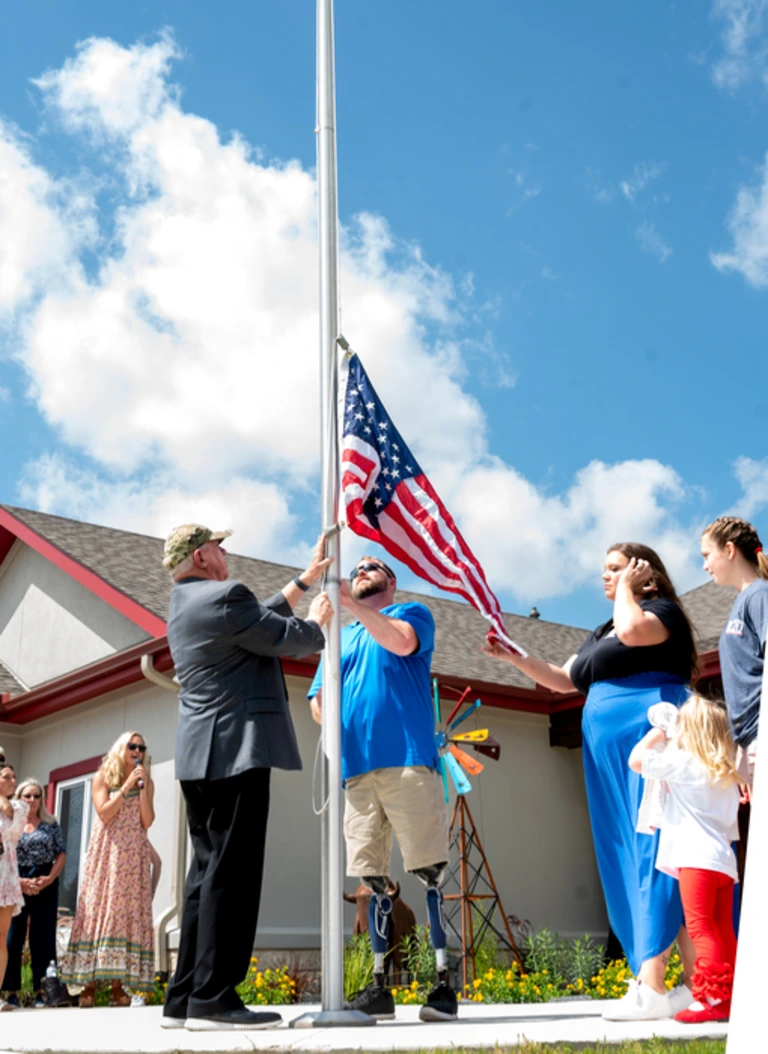 Veteran raising the American flag. Photo courtesy of HFOT.
