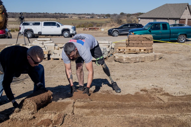 HFOT Veteran laying sod with Populus Financial Group.